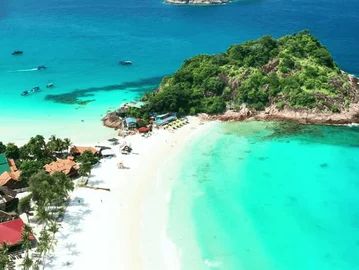 A tropical island with turquoise waters and white sandy beach.