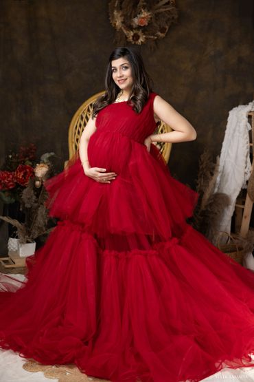 Woman having maternity photo shoot in red dress