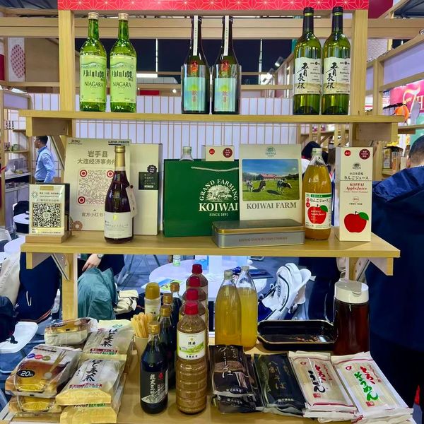 Wooden display shelves with assorted Japanese beverages and food products.
