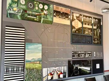 A wall display featuring vintage control panels and scenic photos.