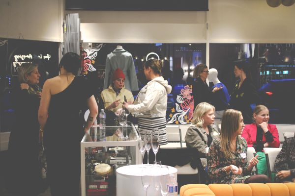 People socializing at an indoor event with drinks.
