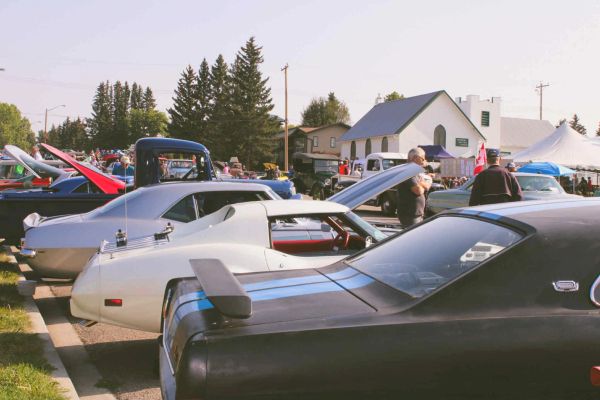 Classic cars lined up at an outdoor car show on a sunny day.