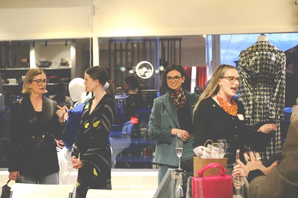 Women socializing at a boutique event.