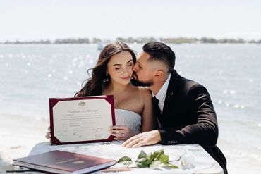 Newly married couple sitting on the waterfront after they have signed the wedding register
