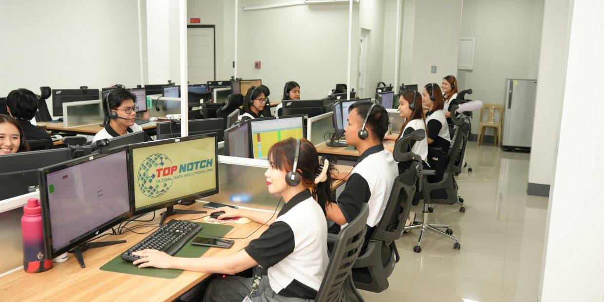 Call center employees working at their desks with headsets in a modern office.