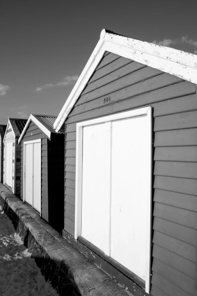 Row of beach huts in black and white.