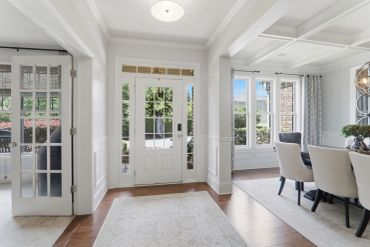 Bright and airy entryway with white walls and wooden floors.