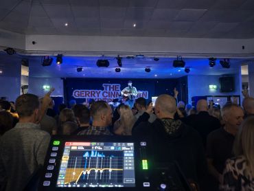 Crowd enjoying a live concert by The Gerry Cinnamon band indoors.