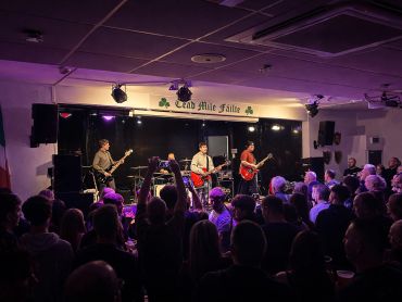 A live band performs on stage at Dead Mile Saloon to an engaged crowd.