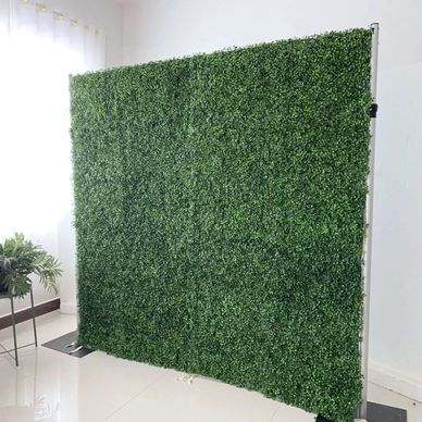 Artificial green hedge wall panel in a bright room.