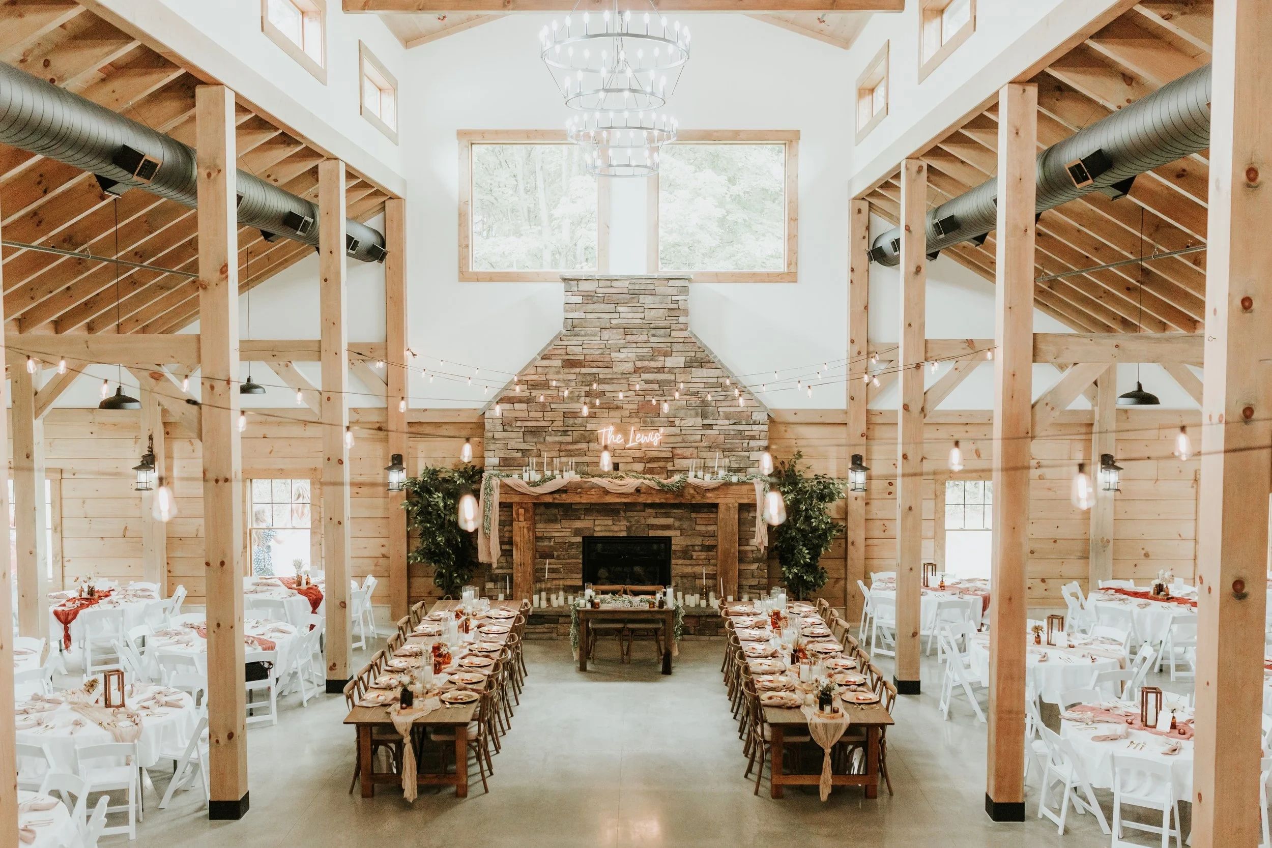 Rustic wedding venue with wooden beams and stone fireplace.