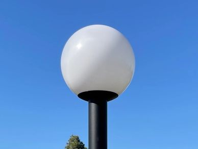 White spherical street lamp against a clear blue sky.