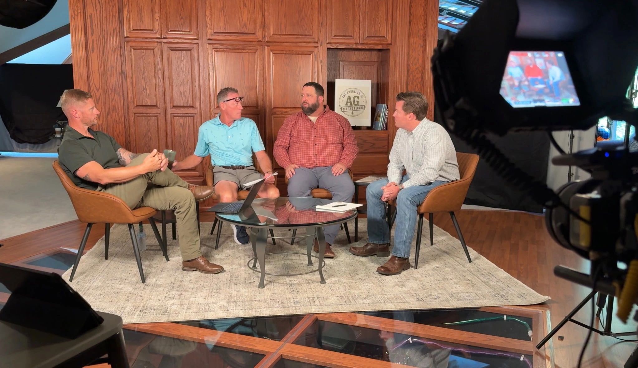 Four men having a discussion in a studio setting.
