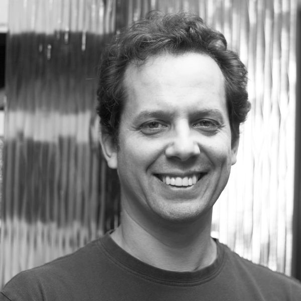 Smiling man in black and white portrait.
