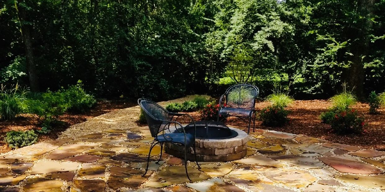 Custom designed patio with a fire pit. Hardscape work completed by Murphy Landscaping & Lawn Inc. 