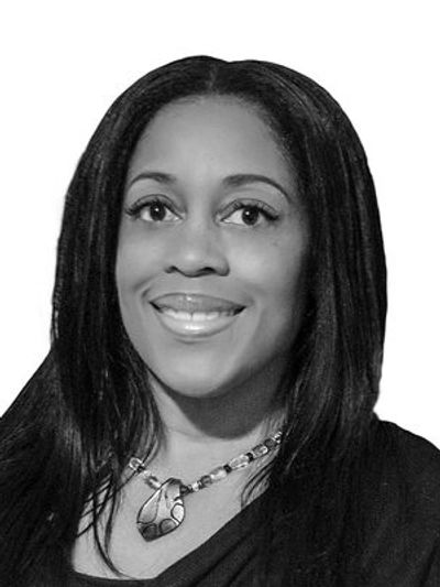 Black and white portrait of a smiling woman with long hair.