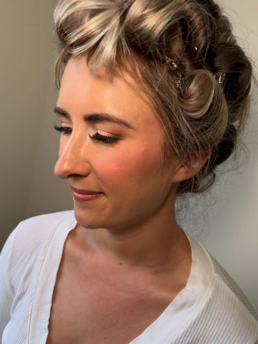Close-up of a woman with styled hair and makeup.