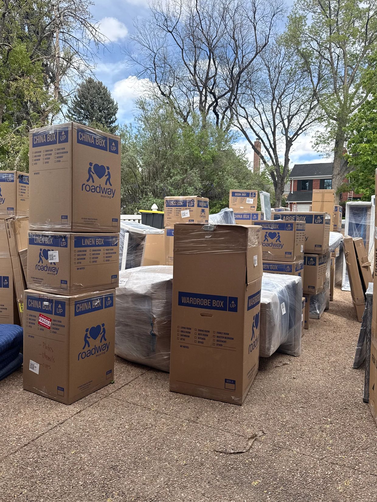 Stack of labeled moving boxes outdoors.