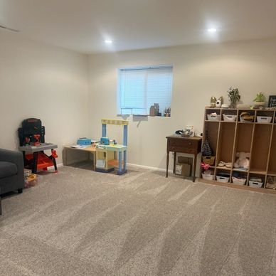 A tidy playroom with toys and storage.