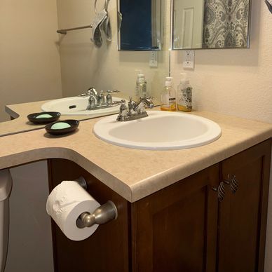 Clean bathroom sink with mirror and soap dispensers.