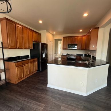 Modern kitchen with wooden cabinets and black countertops.