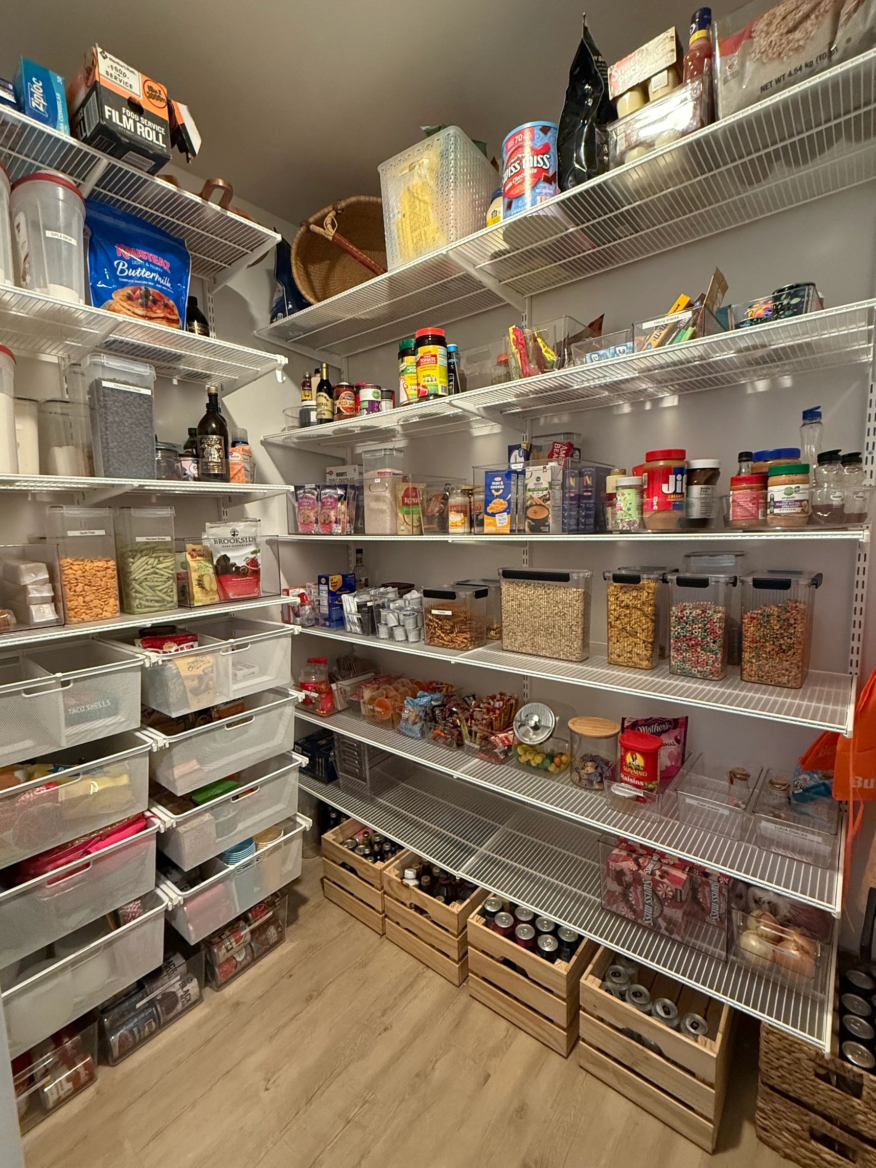 Organized pantry with labeled containers and crates.
