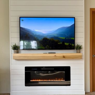 Modern living room setup with TV and electric fireplace.