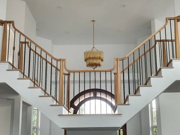 Elegant staircase with wooden handrails and a unique chandelier.