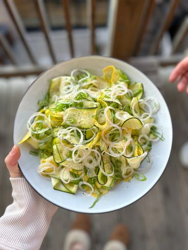 Fresh zucchini and onion salad with a sprinkle of black pepper.