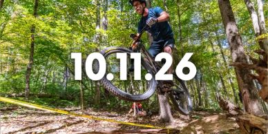 Mountain biker jumps over a log in the forest.