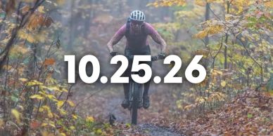 A mountain biker riding through autumn woods with a date overlay.