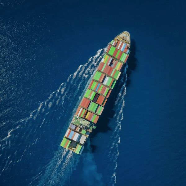 A container ship from above moving up and to the right, representing growth, momentum, and progress