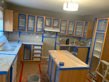 Kitchen cabinets and countertops covered for painting or renovation.