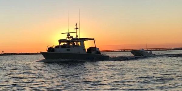 Salvage Tug towing another boat at sunset in the Bahamas