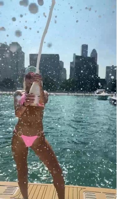 Popping Champagne for a Champagne Shower (But don't drink it! Stay sober!)/Photo courtesy of Boat Safe Chicago pink bikini girl in pink bikini popping champagen in the chicago playpen boating charter charterboat boating 