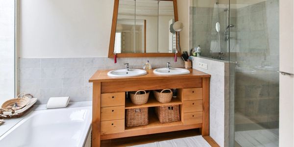 Bathroom with double sink, wood vanity, bath and luxury shower