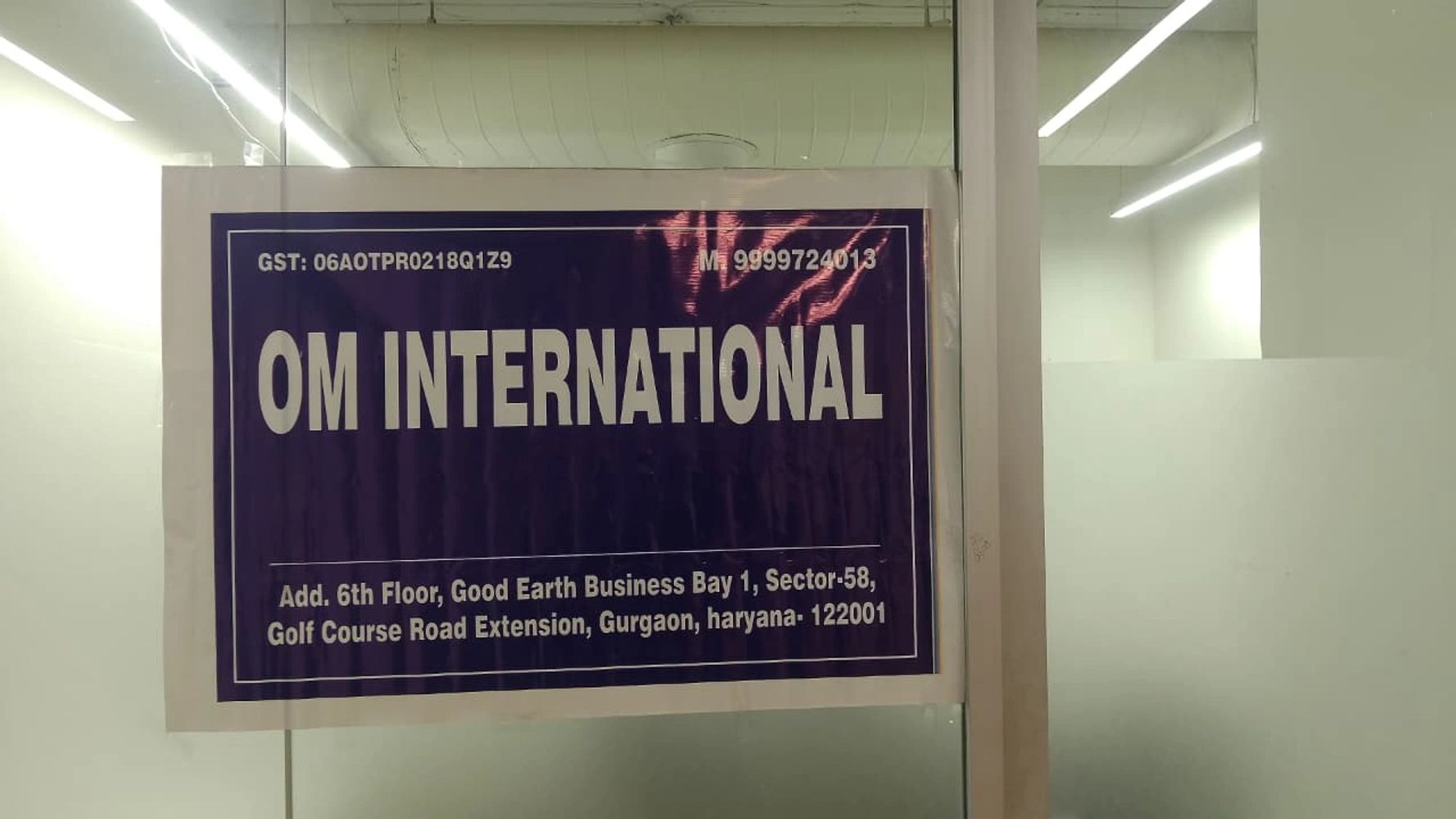 Signboard of OM INTERNATIONAL office in Gurgaon, Haryana.