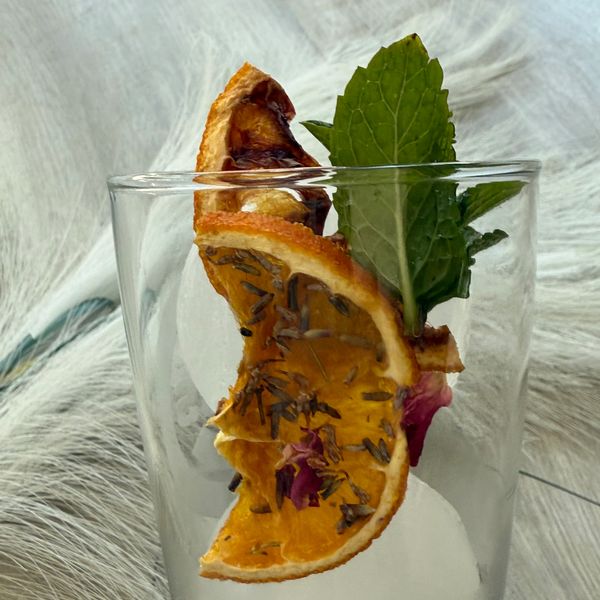 Fresh dehydrated, orange slice with fresh mint, and lavender and rose petals.