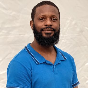Man with beard in blue polo shirt.