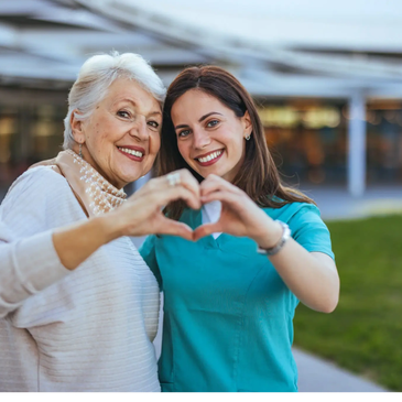 Una mujer mayor y una joven hacen un corazón con las manos.