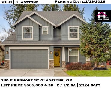 Two-story gray house with a yellow front door and large garage in Gladstone.
