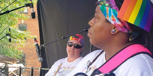 Two musicians performing on stage with colorful attire.