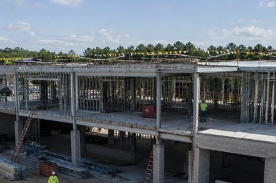 Concrete building under construction with workers.
