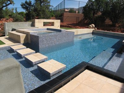 Pool with tiled waterline, spa, and stepping pads across the water