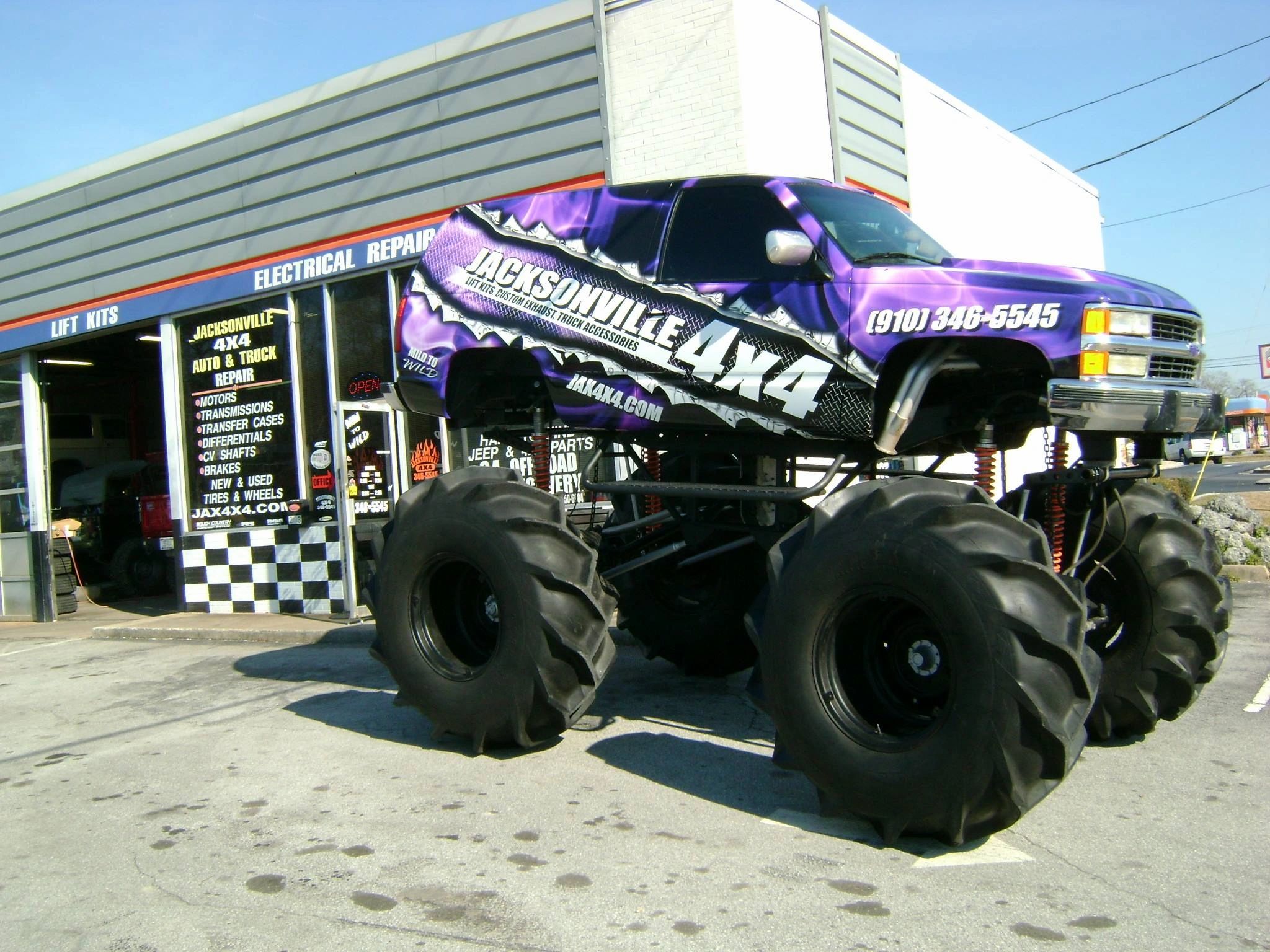 Jacksonville 4x4 Mega truck parked in front of building.