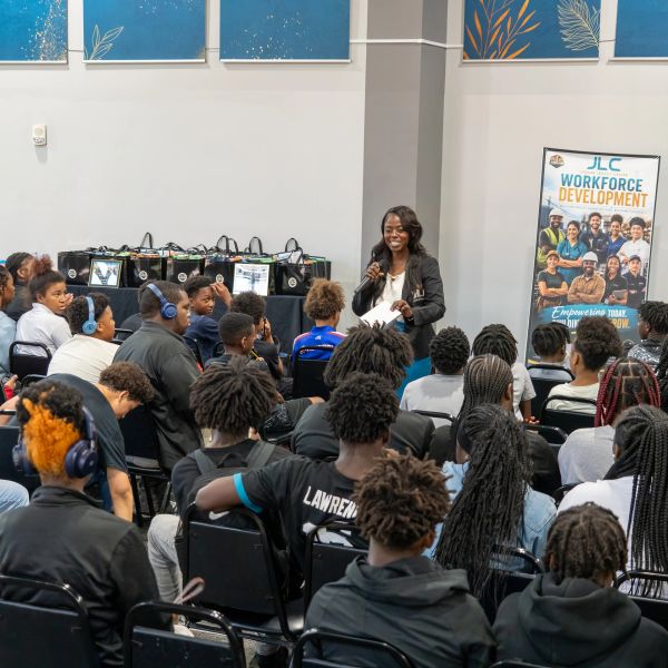 Woman speaking to a group of youth at a workforce development event.