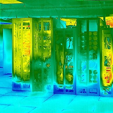 Thermal image of electronic server racks glowing in various heat levels.