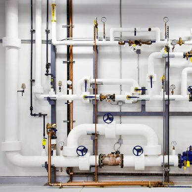 Complex network of insulated and metal pipes with valves and gauges.