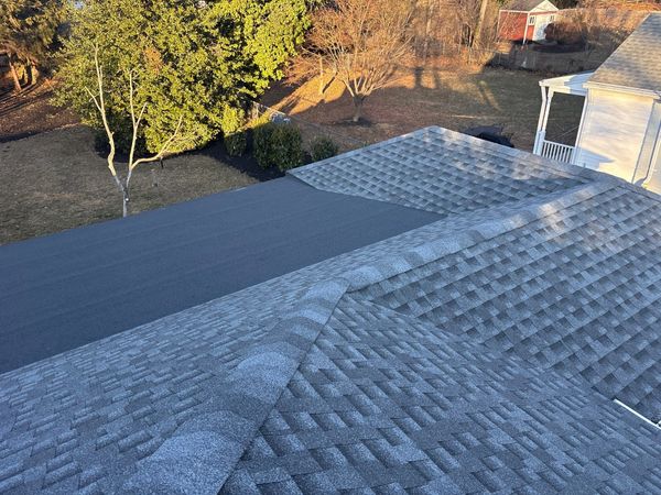 Roof with new and old shingles in the sunlight.
