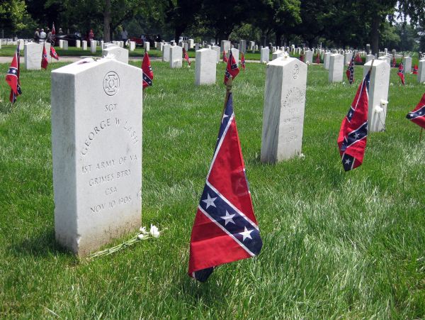 Confederate graves marked with flags in a cemetery.